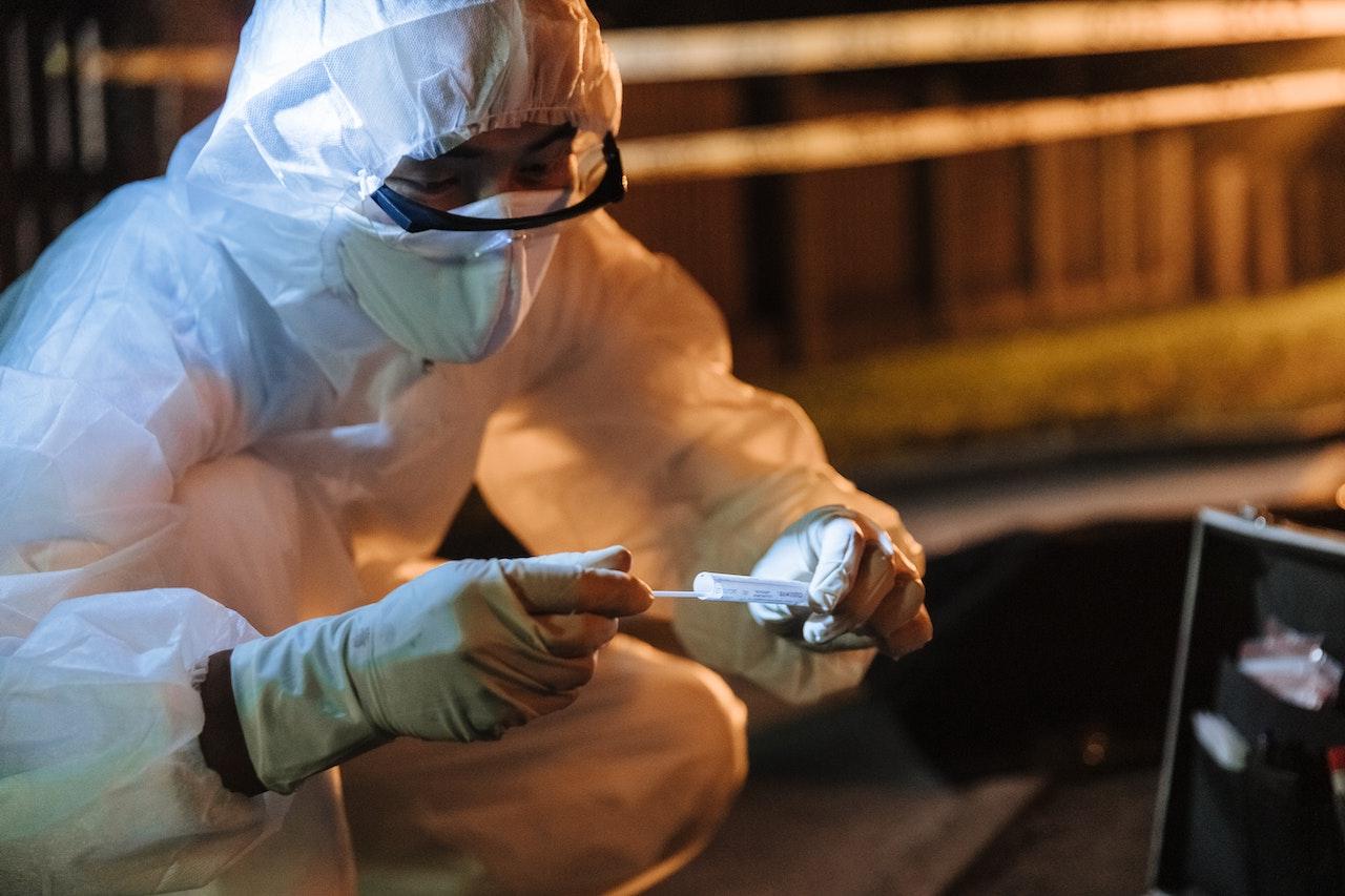 Man in protective gear and White Gloves Holding White Plastic Pack